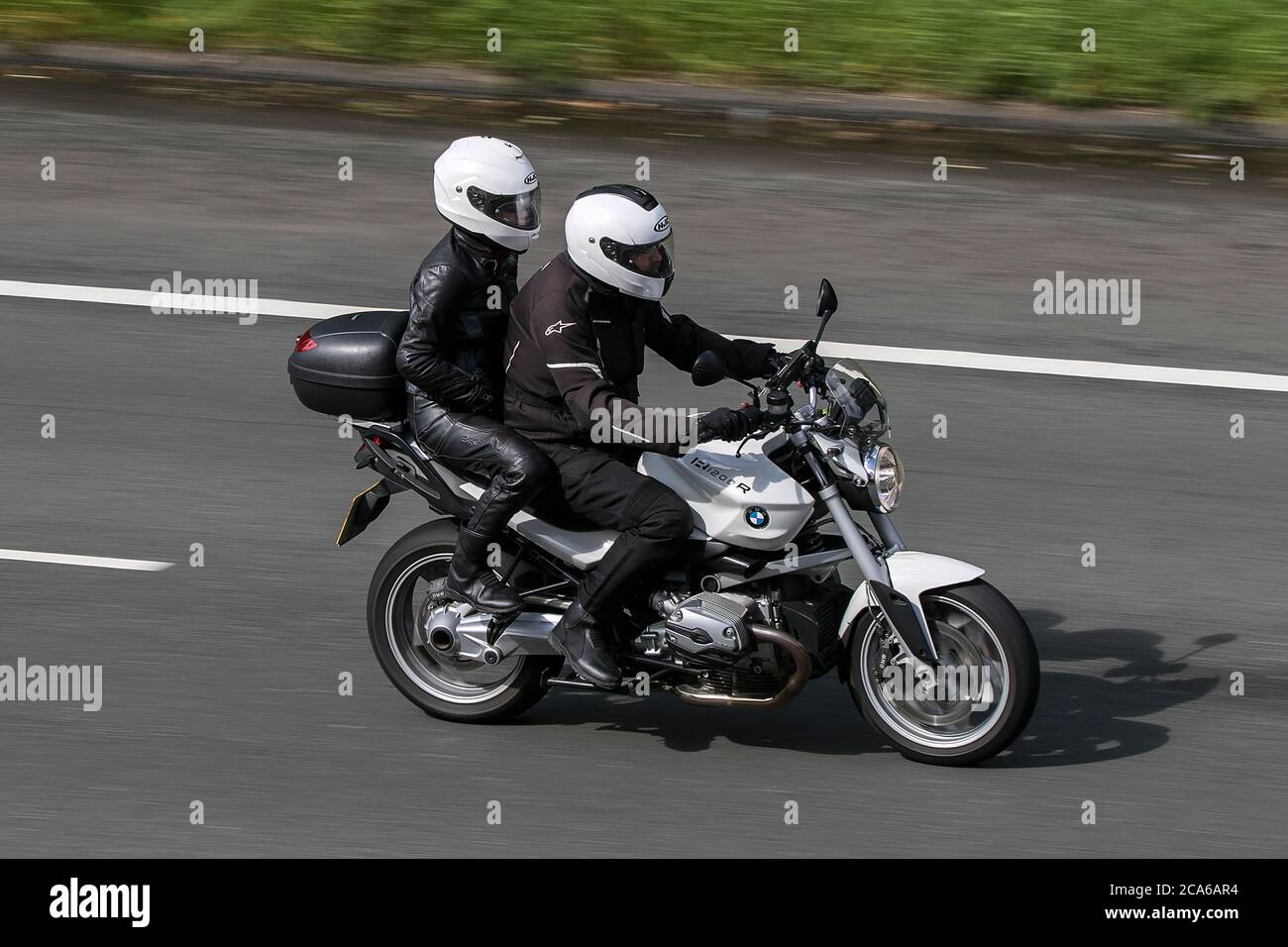 Ein BMW 1200R Motorrad und Fahrer und Sozius fahren auf der M6 Autobahn in der Nähe von Preston in Lancashire, Großbritannien Stockfoto