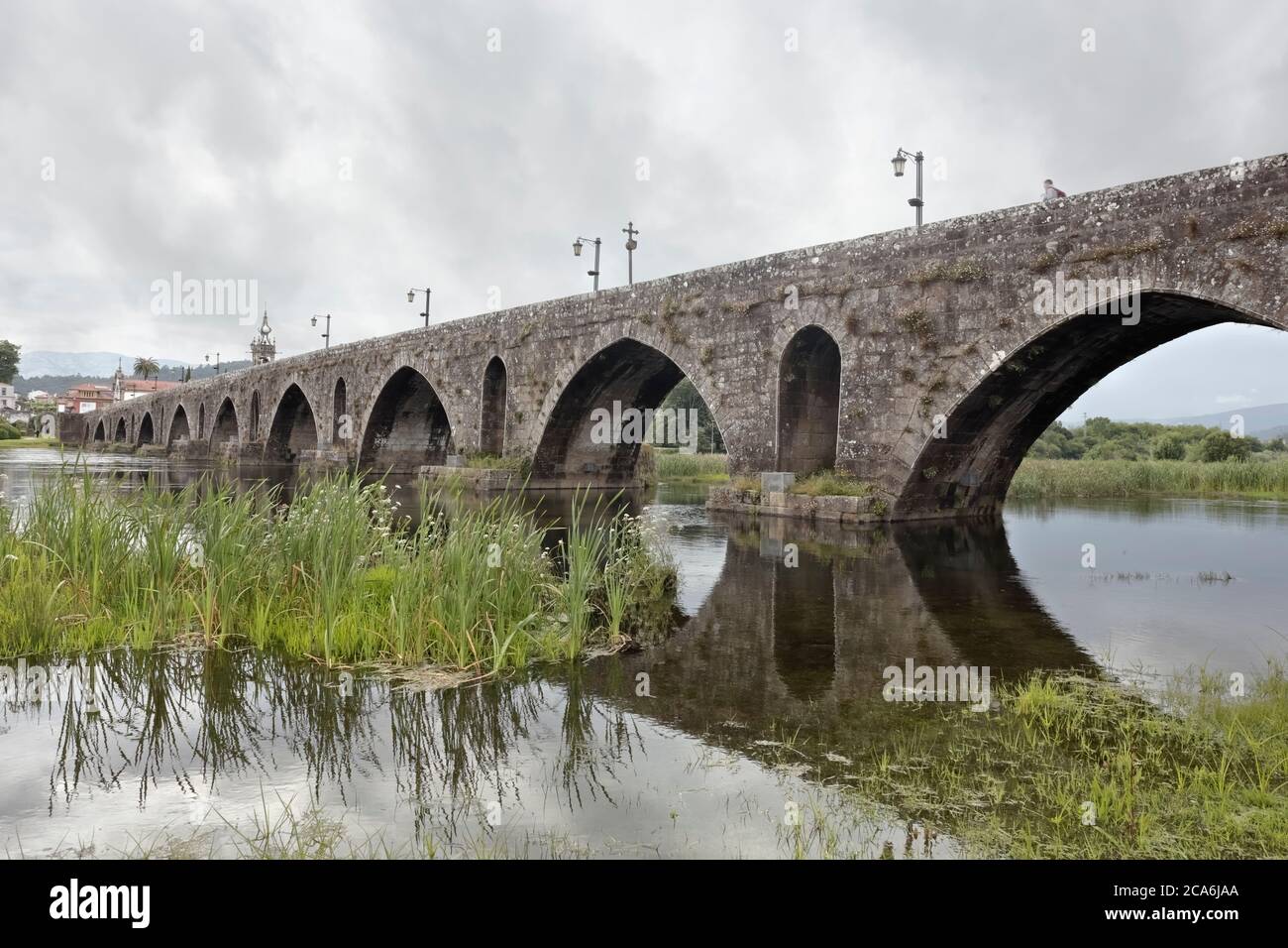 Alte Granitbrücke und Kirche aus der mittelalterlichen Stadt Ponte de Lima an einem regnerischen Tag. nordportugiesischer Weg nach Santiago de Compostela. Stockfoto