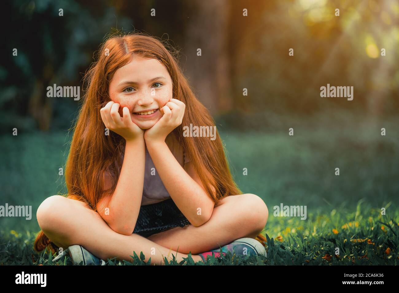 Happy niedlichen kleinen Mädchen im Park sitzen. Stockfoto