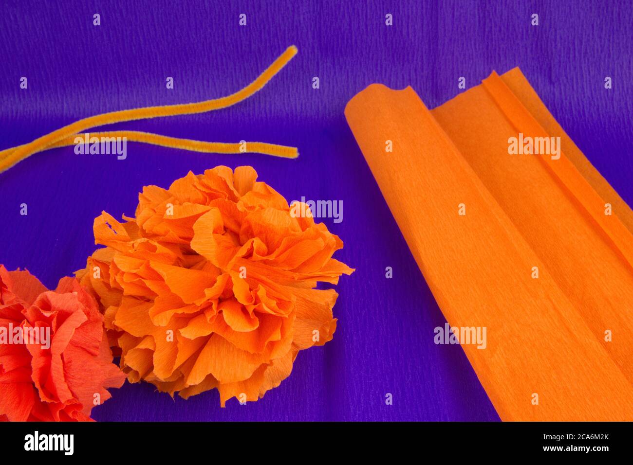 Materialien, die für die Herstellung einer Krepppapierblume, Krepppapier und eines Pfeifenreinigers benötigt werden, die zum Fest der Dia de los muertos in Lateinamerika verwendet werden Stockfoto