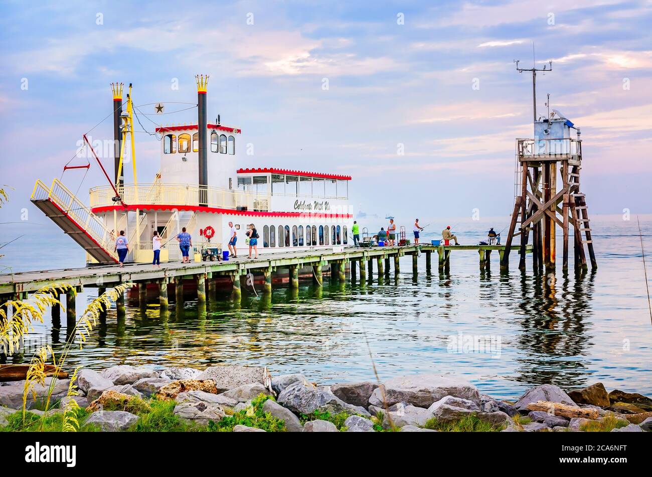 Die Menschen fischen vom öffentlichen Pier neben dem Spirit of Texas Paddle Wheeler Party Boot, 1. August 2014, in Dauphin Island, Alabama. Stockfoto