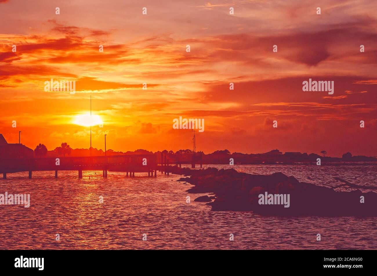 Die Sonne untergeht über dem Wasser, 22. Juli 2020, in Dauphin Island, Alabama. Stockfoto