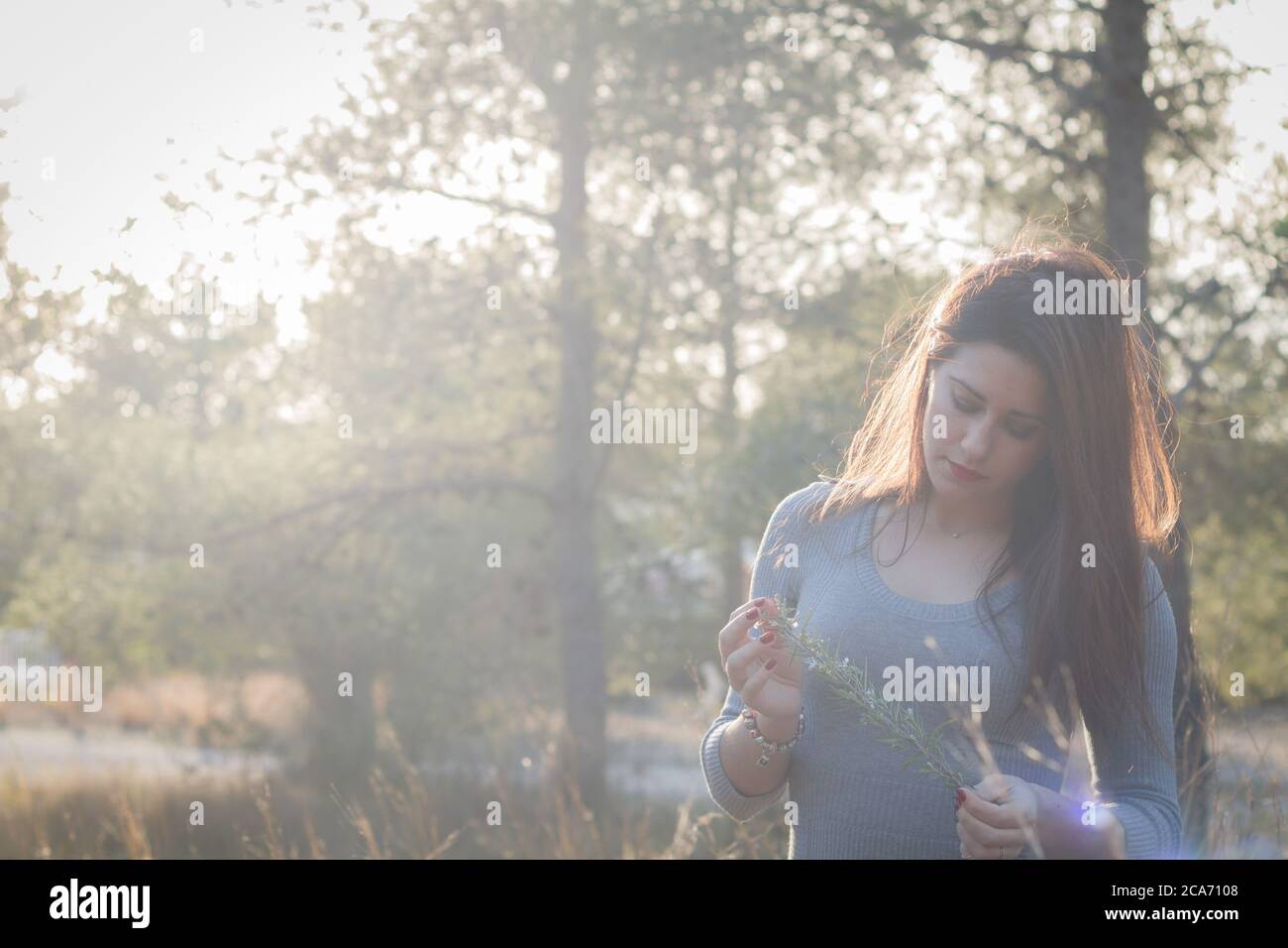 Schöne junge spanische Mädchen in Hintergrundbeleuchtung genießen den Wald Stockfoto