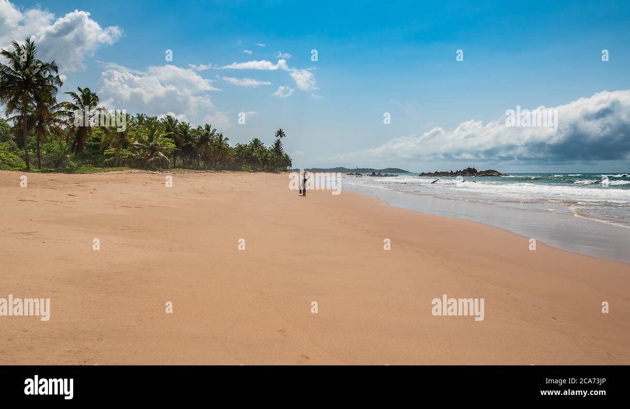 Frau bewegt Gadgets auf der anderen Seite des Strandes in Axim Ghana Westafrika Stockfoto