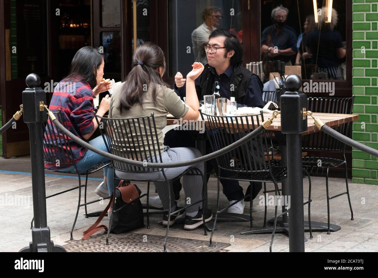 Gäste können während des Programms „Eat Out to Help Out“ an Restauranttischen im Freien in der königlichen Straße essen. Hier erhalten Gäste einen Rabatt auf Mahlzeiten, um die Restaurants und Pubs nach der Sperre zu stärken. Stockfoto