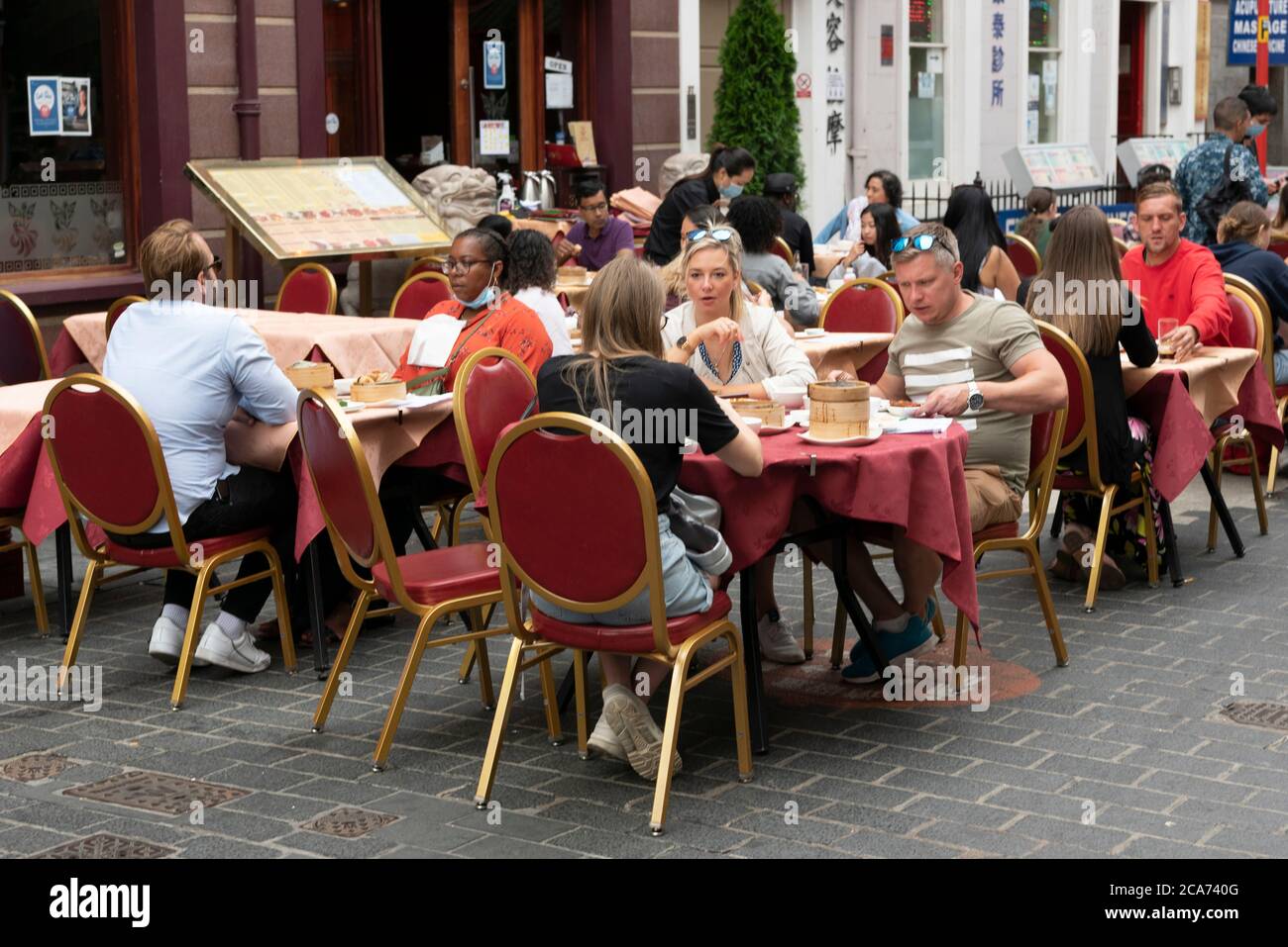 Gäste können während des „Eat Out to Help Out“-Programms an Restauranttischen im Freien in Chinatown speisen. Hier erhalten Gäste einen Rabatt auf Mahlzeiten, um die Restaurants und Pubs nach der Sperre zu stärken. Stockfoto