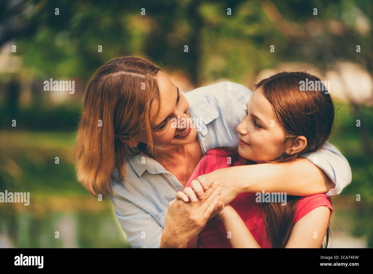 Glückliche Mutter und kleine Tochter im Park. Stockfoto