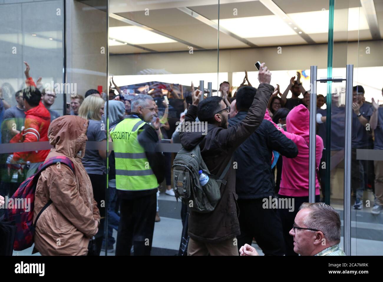 Sydney, Australien. 25. September 2015. Im Bild: Die Türen werden geöffnet, um die ersten Käufer um 8 Uhr morgens einzulassen, während Apple-Mitarbeiter sie anfeuern und klatschen. Lindsa Stockfoto