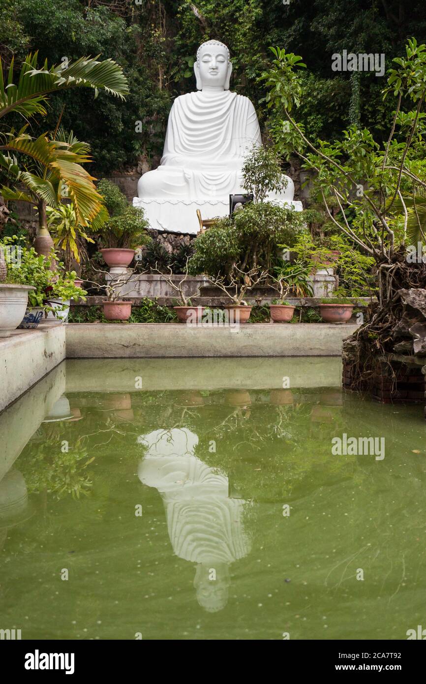 Da Nang / Vietnam - 15. Januar 2020: Buddha-Skulptur aus weißem Marmor mit Spiegelung auf Poolwasser in Marmorbergen Stockfoto