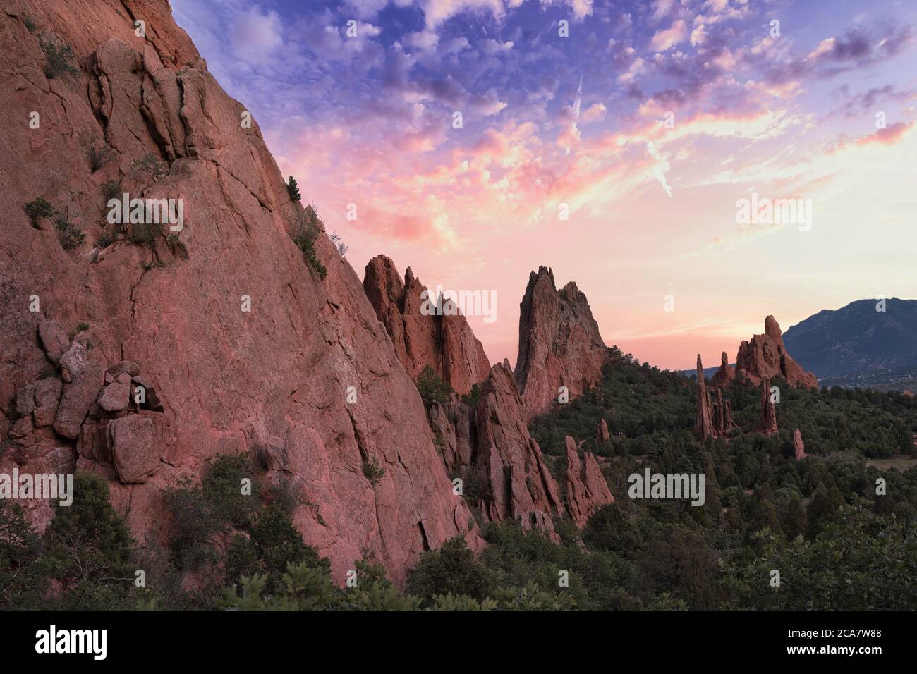 Garten der Götter mit farbenprächtigem rosa und violettem Sonnenuntergang. Schöne Farben werfen Licht auf die Felsformationen in colorado Springs. Bunte Wolken, gree Stockfoto