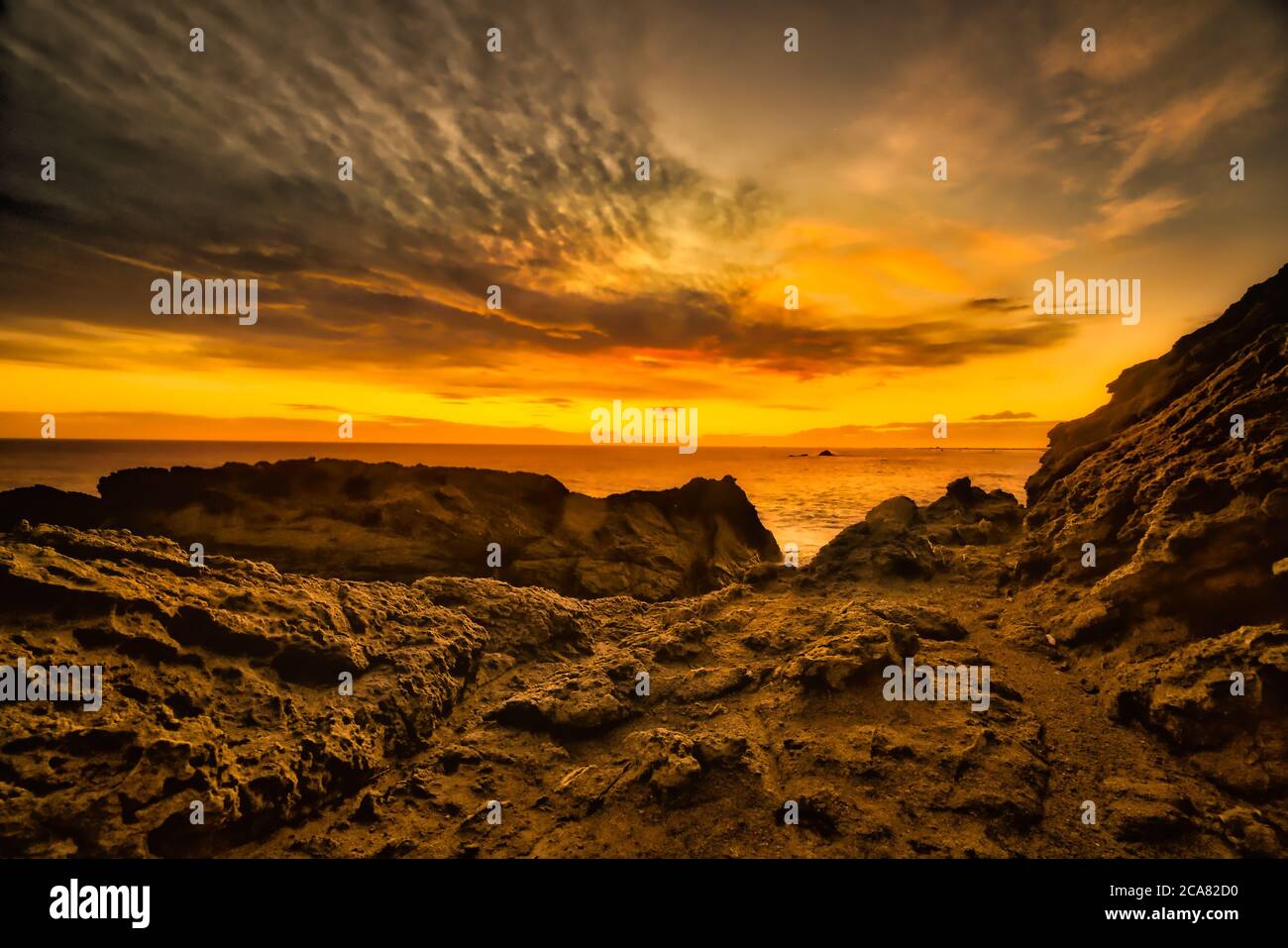 Dramatische Farben des Sonnenuntergangs auf dem extremen felsigen Vorland am Cape Palliser Wairarapa Neuseeland Stockfoto