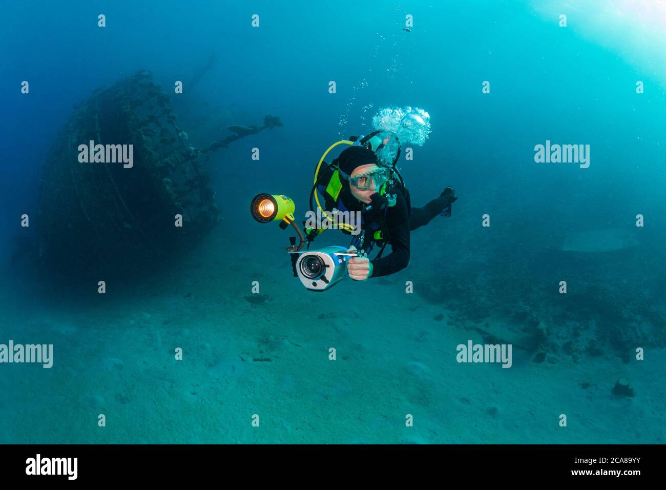 Taucher mit Unterwasser-Videokamera taucht in der Nähe des Wracks, Rotes Meer. Stockfoto