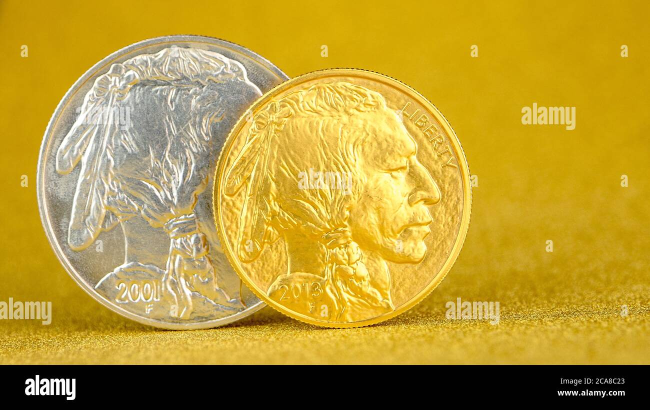Silber und golden amerikanischen Büffel eine Unze Münzen auf Silber und goldenem Hintergrund, Bild in zwei Hälften geteilt Stockfoto