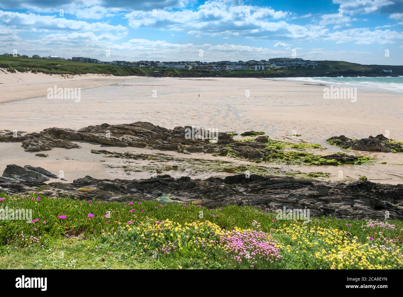 Eine einzige Figur, die am Fistral Beach entlang ging, war aufgrund der Sperre des Coronavirus Covid 19 in Newquay in Cornwall verlassen. Stockfoto