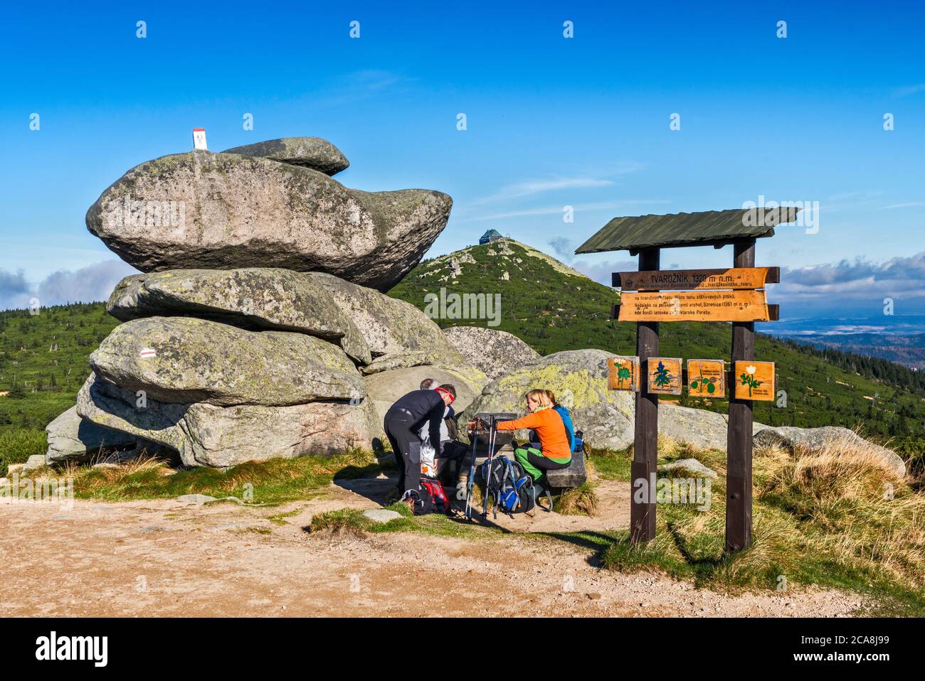 Wanderer am Picknicktisch an der Felsformation, internationaler Grenzposten auf der Spitze, in Karkonosze-Bergkette, Karkonosze Natl Park, Niederschlesien, Polen Stockfoto
