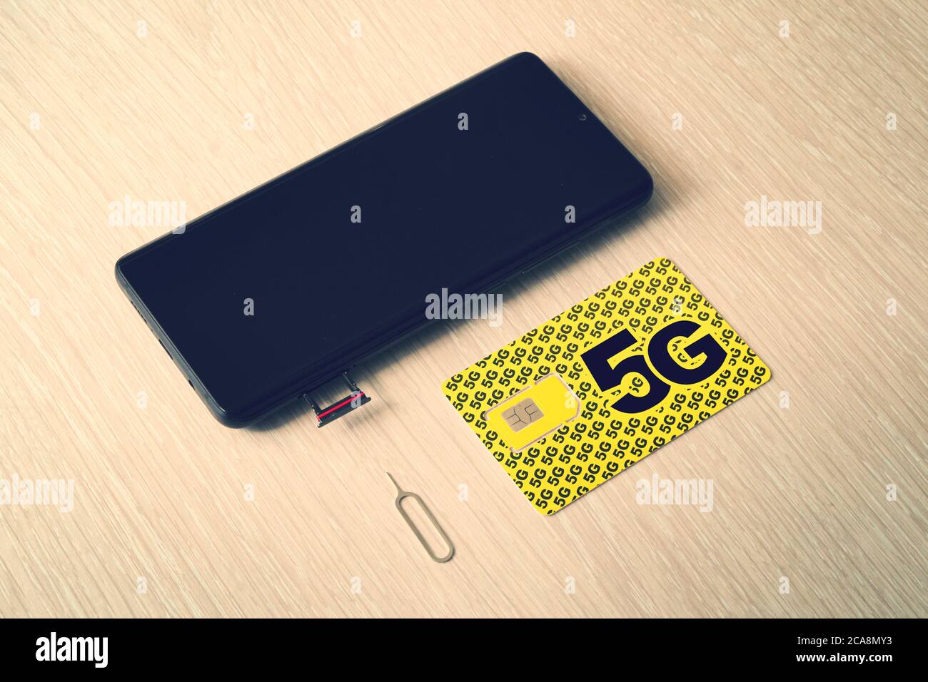 Breitband 5G Mobilkommunikationstechnik Konzept SIM-Kartenfach, Dual SIM-Kartensteckplatz mit zwei Nano-SIM-Karten auf Holzhintergrund. Stockfoto