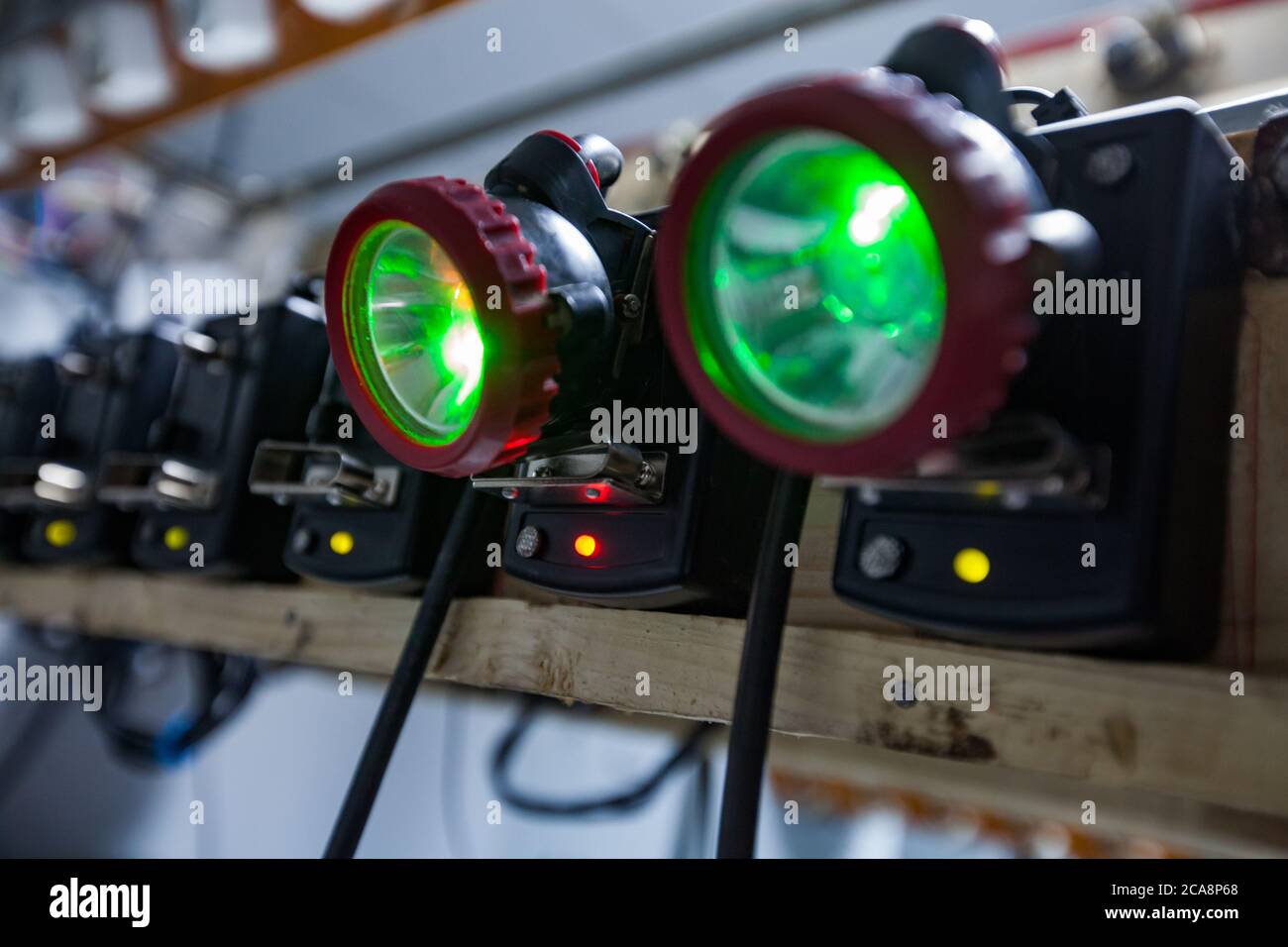 Goldbergbau und Verarbeitungsanlage Steinbruch. Ladestation. Grüne Lichter der vollständig aufgeladenen Bergarbeiterscheinwerfer. Unscharfer Hintergrund. Geringe Schärfentiefe. Stockfoto