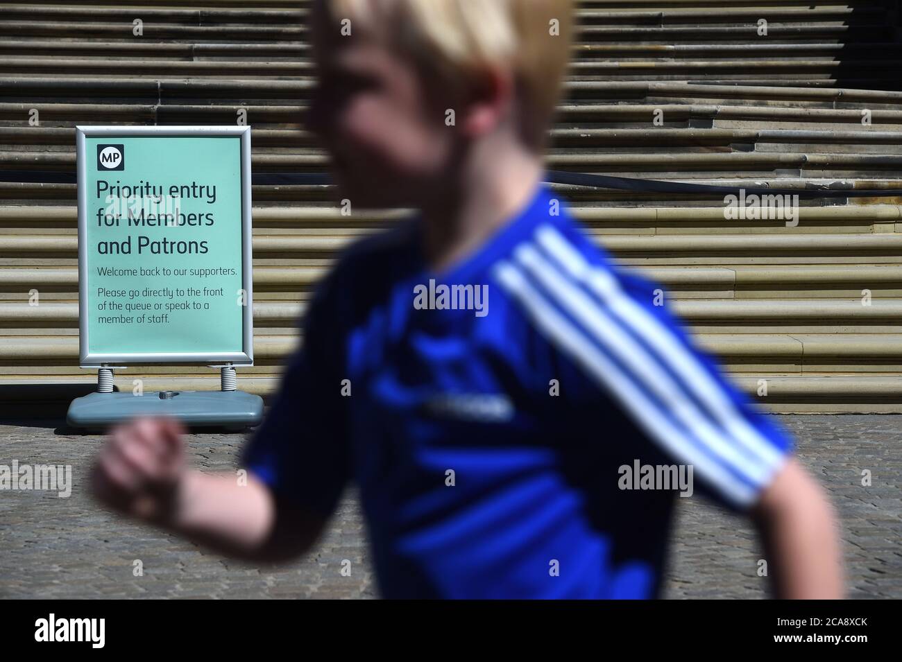 Ein Junge läuft an einem Schild vor dem Natural History Museum in South Kensington, London, vorbei, da es zum ersten Mal seit der Coronavirus-Sperre wieder für die Öffentlichkeit zugänglich ist. Stockfoto