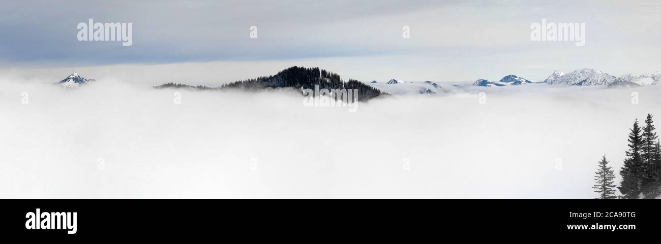 Winter Panoramablick auf schneebedeckte Berge über den Wolken des Inversionsnebels. Blick vom Riedberger Horn in Allgau, Bayern, Deutschland. Stockfoto