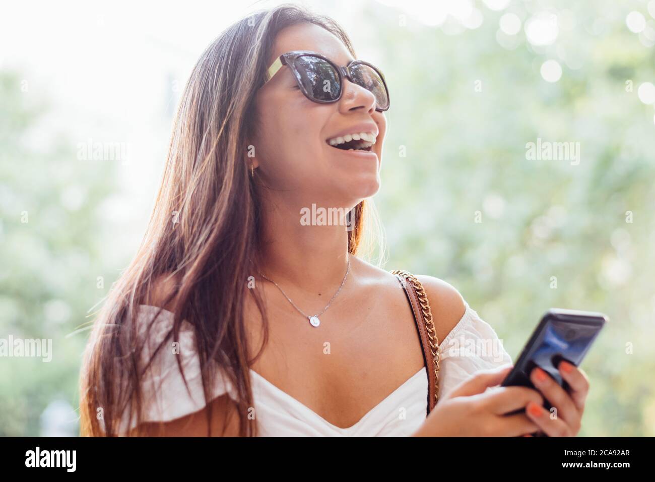 Lächelnde Frau mit ihrem Smartphone Stockfoto