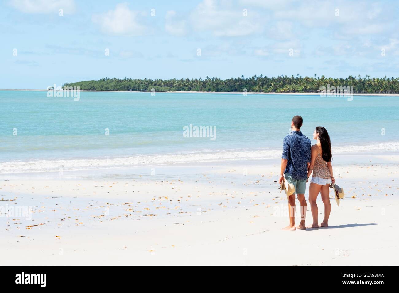 Ein gut aussehendes lateinamerikanisches Paar an einem einsamen Strand mit Rücken zur Kamera, Brasilien, Südamerika Stockfoto