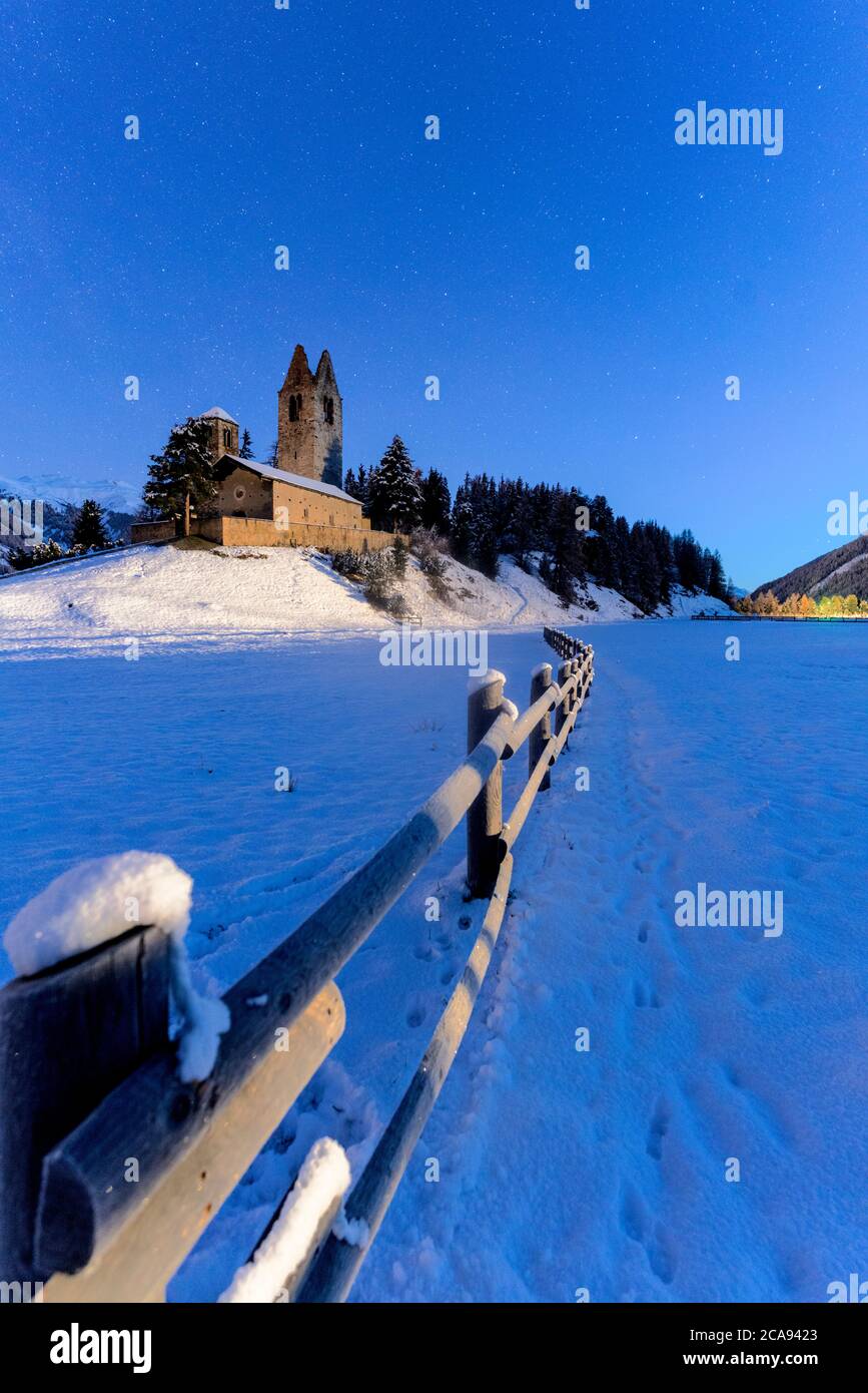 Holzzaun im Schnee rund um die Kirche von San Gian, Celerina, St. Moritz, Engadin, Kanton Graubünden, Schweiz, Europa Stockfoto