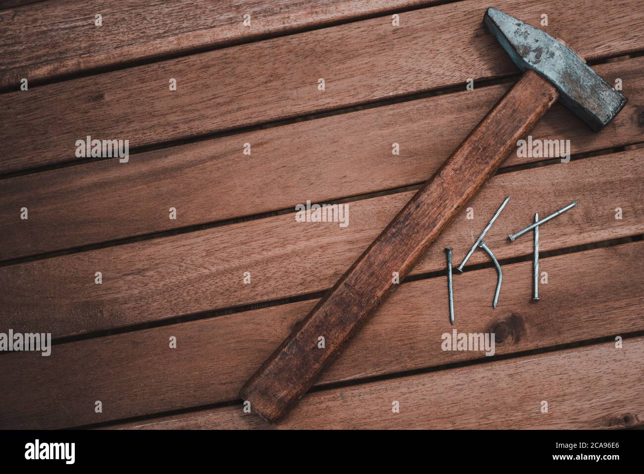 Der alte Zimmermann Hammer, um die Nägel auf dem Holztisch zu schlagen. Holzhintergrund Stockfoto