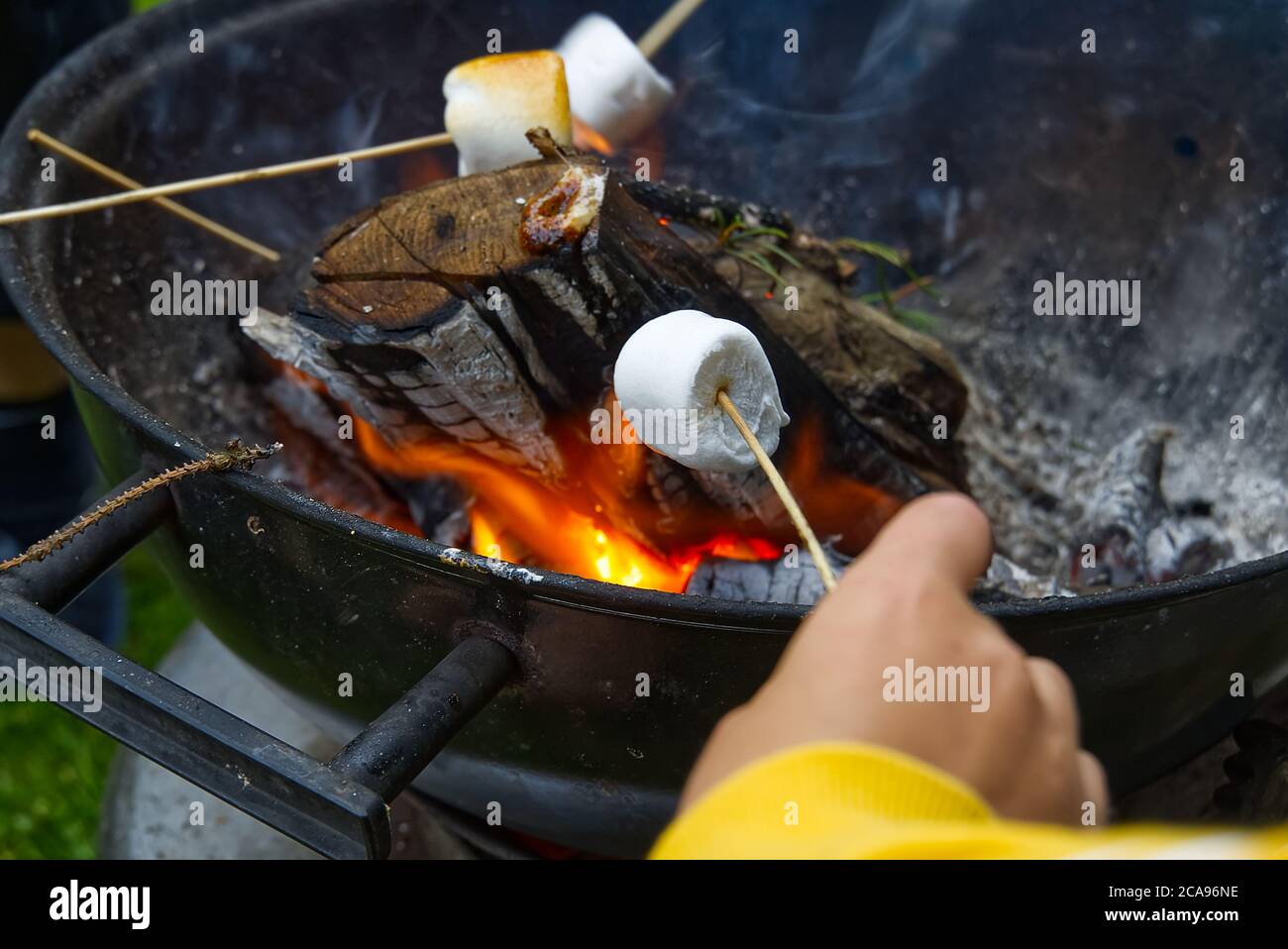 Kochen Marshmallow auf Holzstab über Feuer. Stockfoto