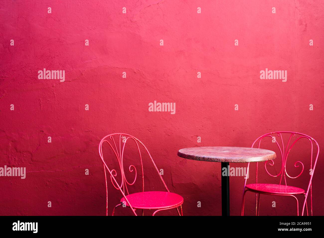 Pink Street Cafe Tisch mit Stühlen an pinker Gebäudewand Stockfoto