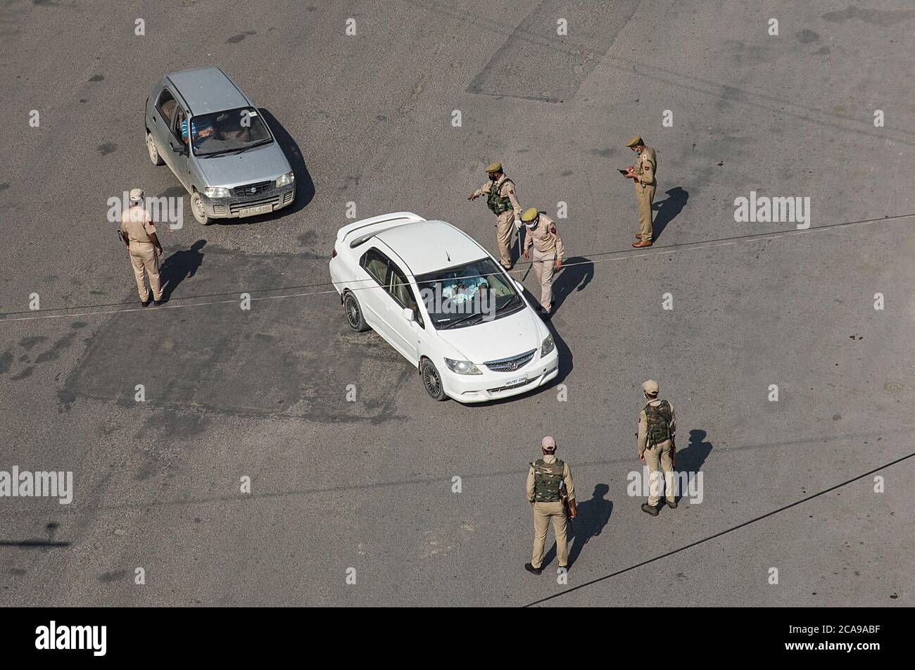 Srinagar, Kaschmir. August 2020. Polizisten halten ein Fahrzeug auf einer Straße während einer Sperre in Srinagar Stadt, der Sommerhauptstadt des indischen kontrollierten Kaschmir, 5. August 2020. Die Behörden im unsicheren indisch kontrollierten Kaschmir verhängten am Mittwoch eine strikte Sperre am Jahrestag der Aufhebung des Sonderstatus der Region, um Protestdemonstrationen gegen den Umzug zu verhindern. (Xinhua/Javed Dar) Quelle: Xinhua/Alamy Live News Stockfoto