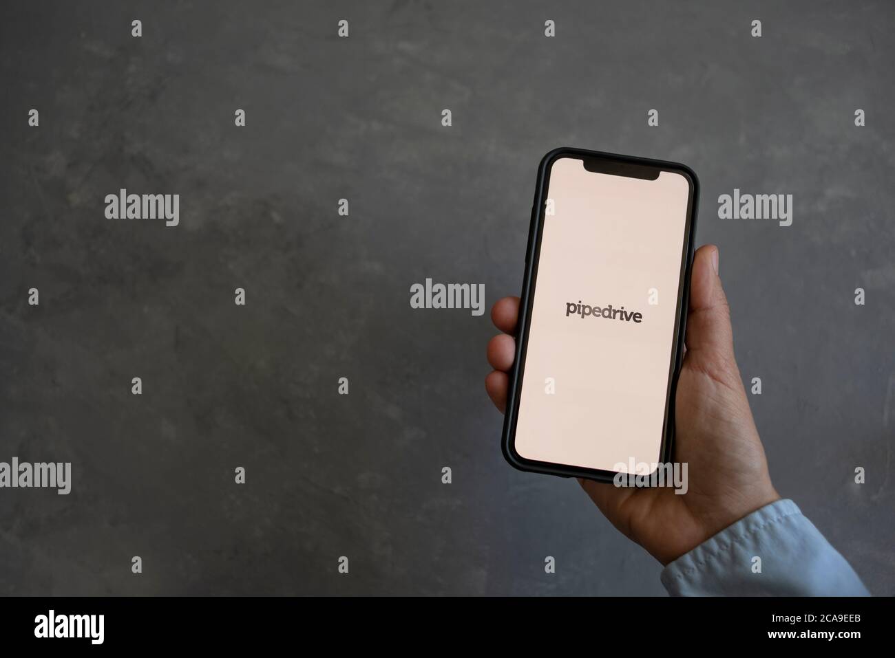 Tallinn, Estland - 16. Juli 2020: Smartphone in der Hand mit Pipedrive-Logo auf dem Bildschirm auf grauem Hintergrund Stockfoto