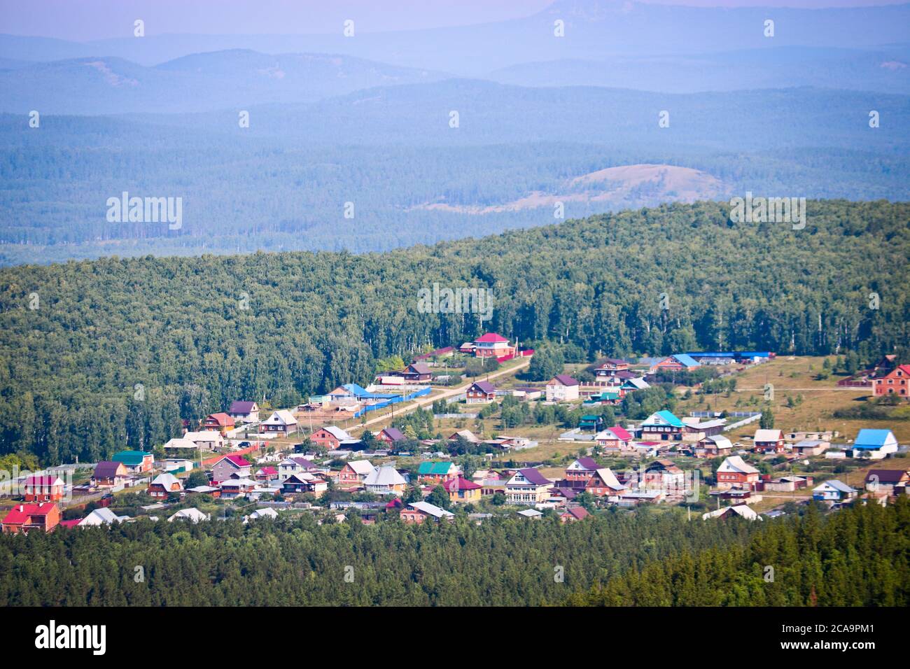 Blick auf das Dorf und Kiefernwälder vom Tschaskowskij Kamm. Uralgebirge. Öko-Tourismus und Wanderkonzept. Stockfoto