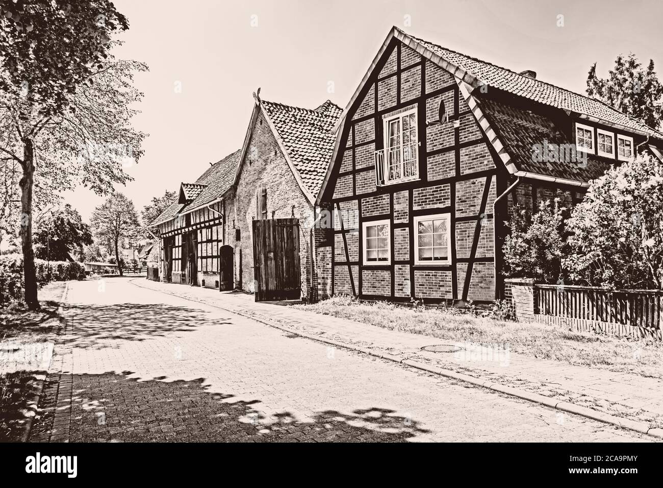 Sepia getönte Bild von historischen Scheunen im Dorf Ahlden, Niedersachsen, Deutschland Stockfoto