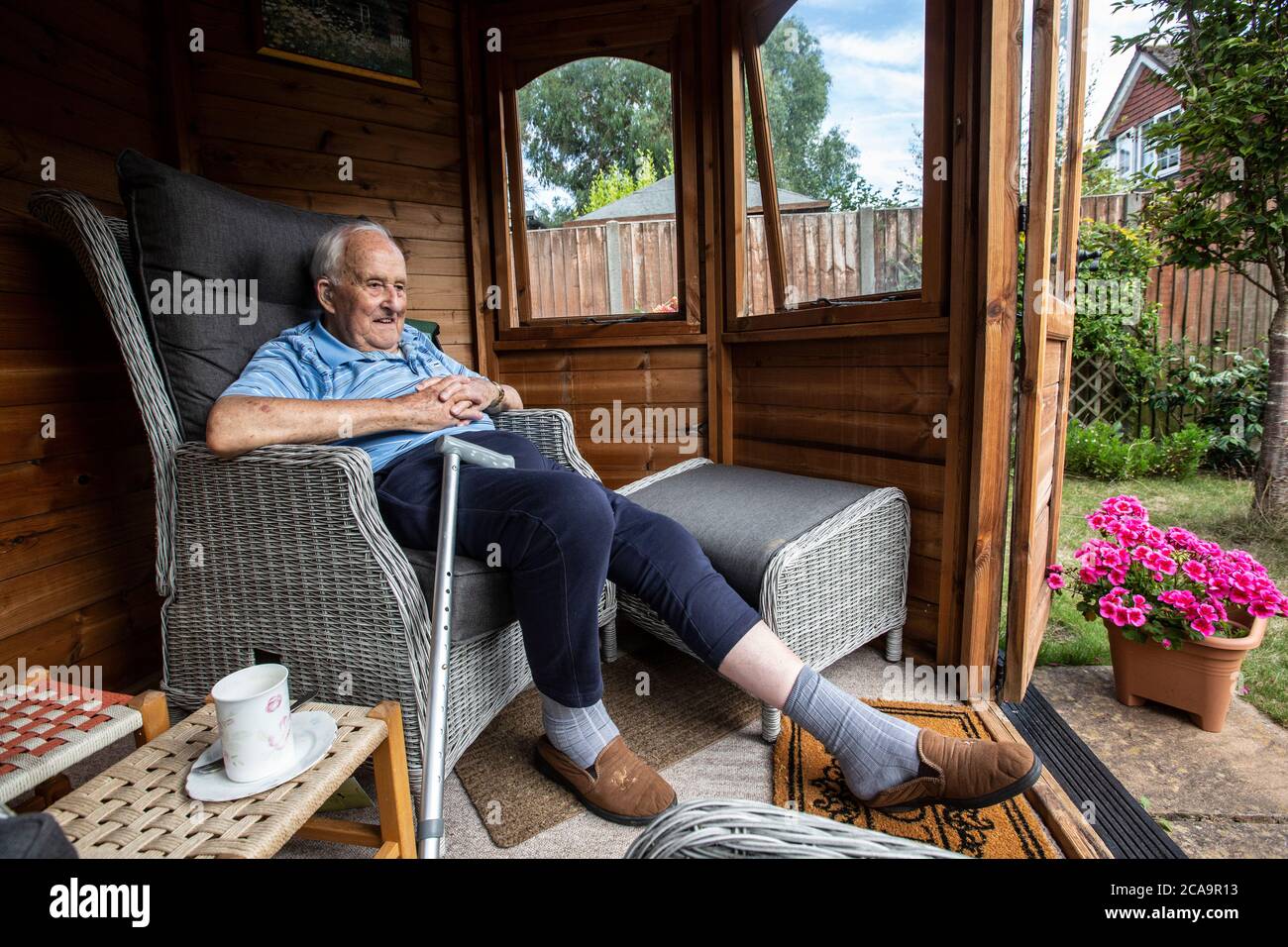 Ältere Paar in den 80ern genießen das warme Sommerwetter in ihrem Garten Sommerhaus, England, Vereinigtes Königreich Stockfoto