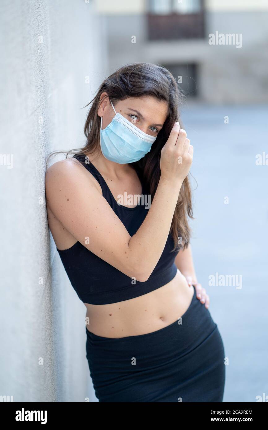 Junge Frau trägt chirurgische Maske auf Gesicht in öffentlichen Räumen. Coronavirus Verbreitung Schutzmaske Schutz gegen Influenza-Viren und Krankheiten. P Stockfoto