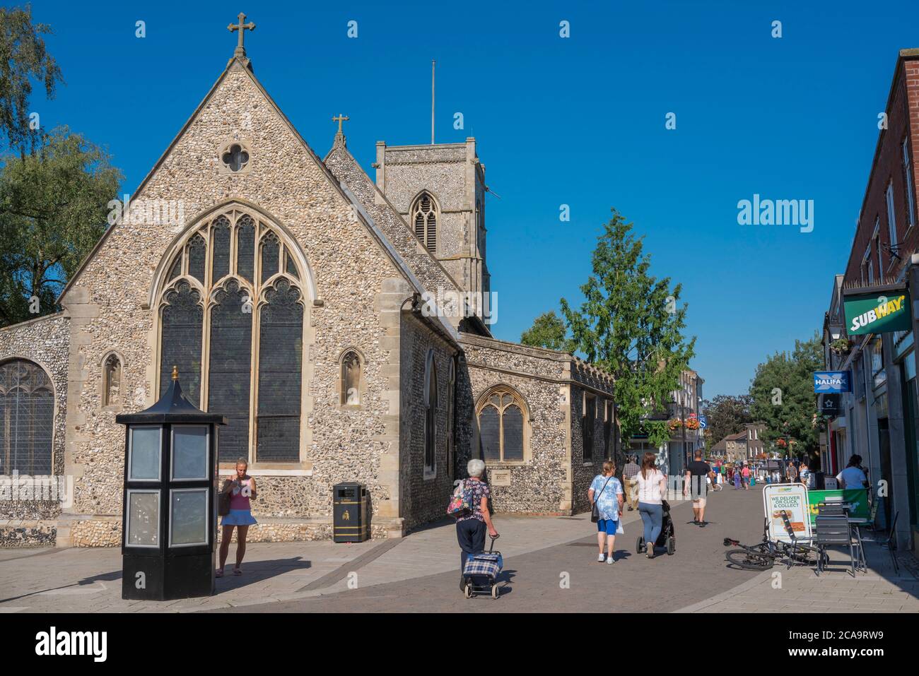 Thetford Norfolk, Blick im Sommer auf Menschen, die an St Cuthbert's Church in der King Street - der Haupteinkaufsstraße in Thetford, Norfolk, Großbritannien, vorbeigehen Stockfoto