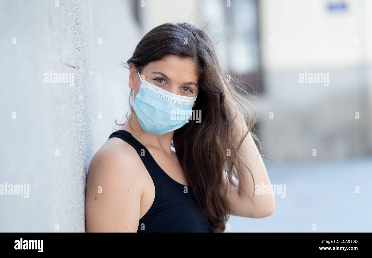 Junge Frau trägt chirurgische Maske auf Gesicht in öffentlichen Räumen. Coronavirus Verbreitung Schutzmaske Schutz gegen Influenza-Viren und Krankheiten. P Stockfoto