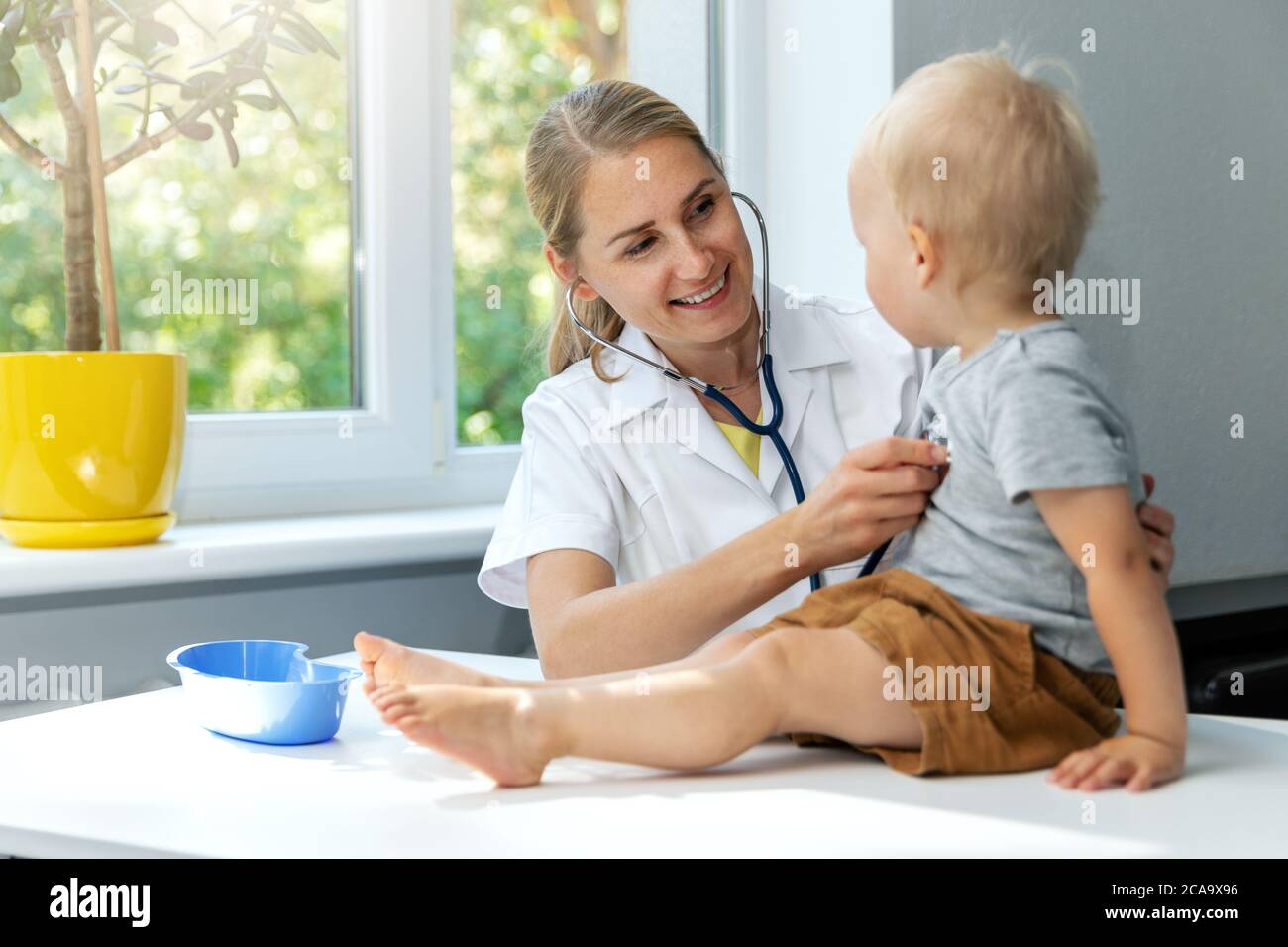 Arzt untersucht ein Kind Patienten durch Stethoskop in der Klinik Büro. Kleiner Junge bei Kinderarzt Termin Stockfoto