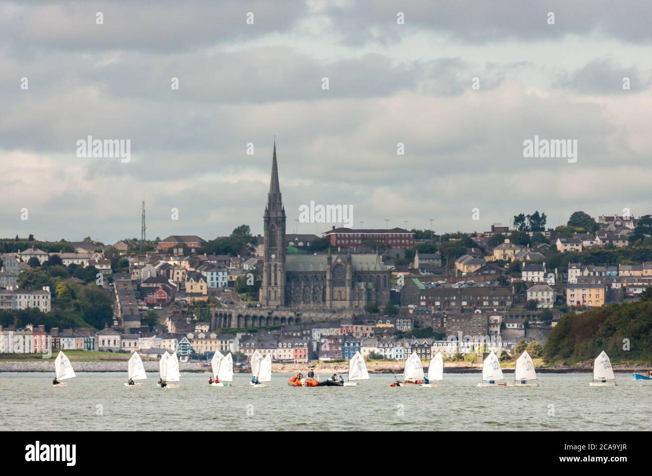 Crosshaven, Cork, Irland. August 2020. Eine Gruppe von Optimist Schlauchbooten vom Royal Cork Yacht Club Training im Hafen von Cork vor dem Hintergrund der St Colman's Cathedral in Cobh, Co. Cork, Irland. - Credit; David Creedon / Alamy Live News Stockfoto