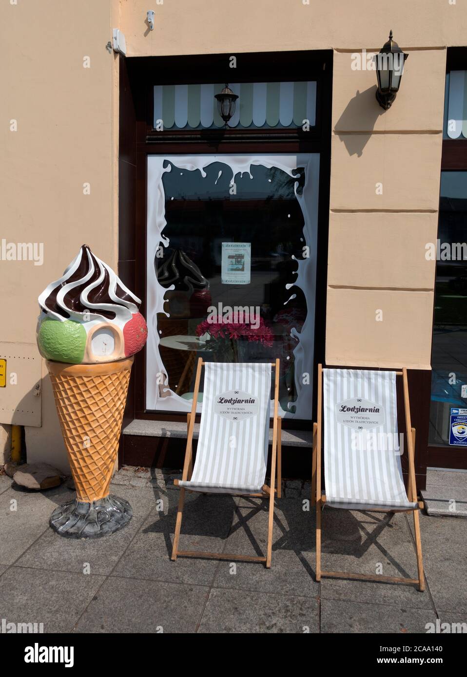 Polnische Eisdiele mit dekorativem Kegel und Terrassenstühlen vor dem Hotel. Tomaszow Mazowiecki Mittelpolen Stockfoto