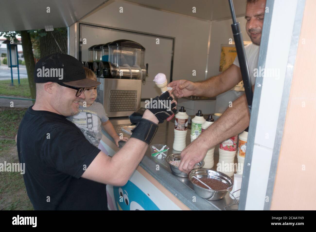 Vater und Sohn holen sich einen Eiskegel von einem Händler am Straßenrand. Rzeczyca Mittelpolen Europa Stockfoto