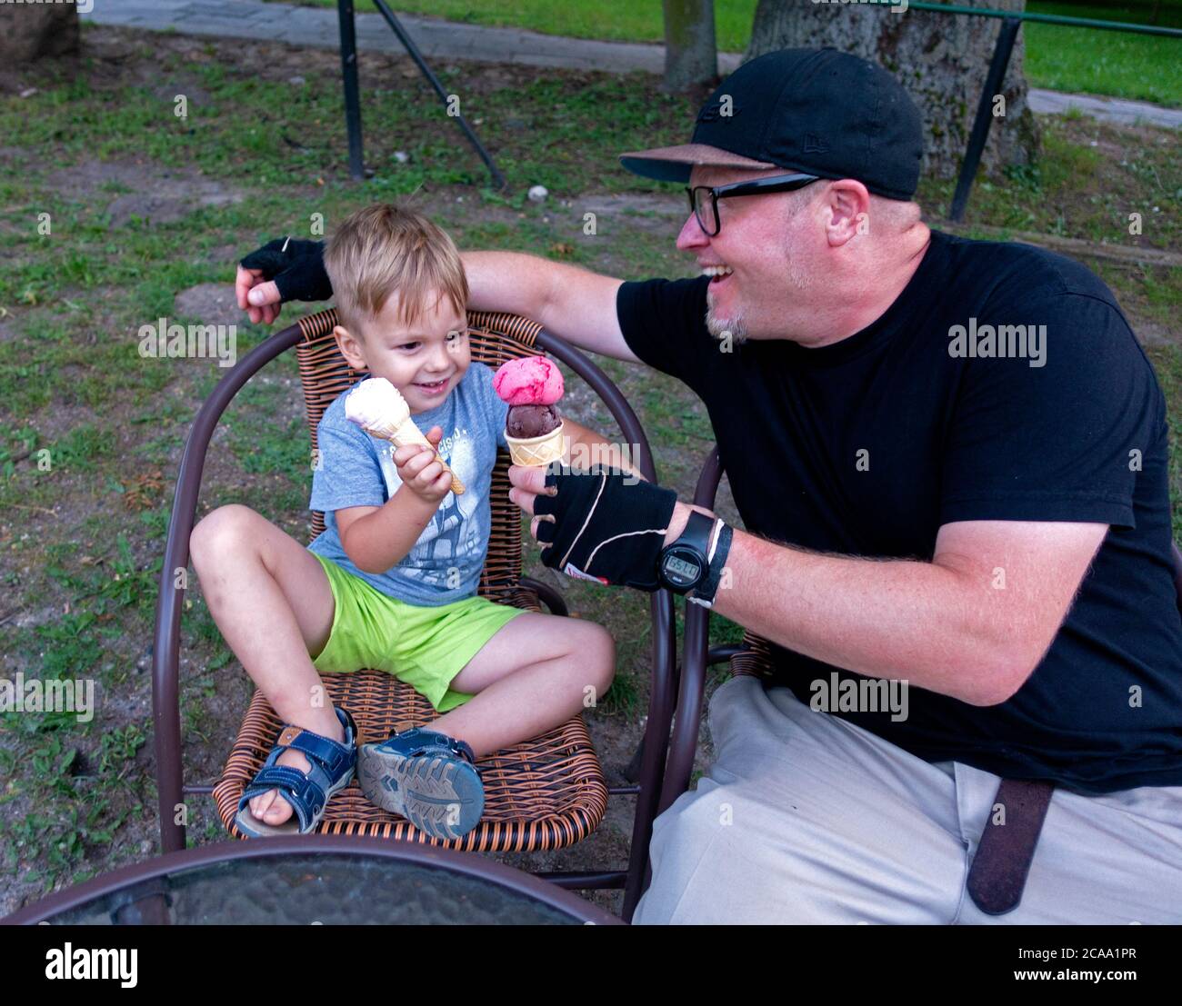 Vater und Sohn toasting Eiszapfen zusammen auf einer Terrasse im Freien. Rzeczyca Mittelpolen Europa Stockfoto