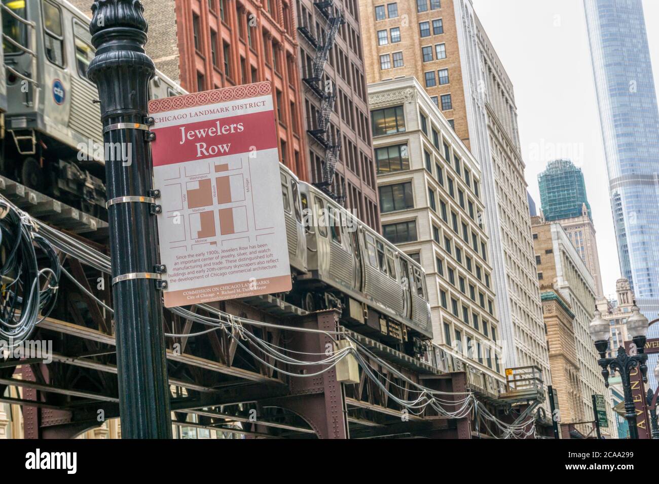 Schild für Jewelers Row, ein Chicago Landmark District, auf Wabash Avenue mit einem vorbeifahrenden Chicago El Zug. Stockfoto