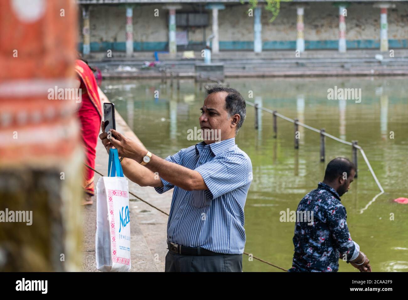 Mayiladuthurai, Tamil Nadu, Indien - Februar 2020: Ein indischer Mann nimmt ein Selfie am heiligen Tank des alten Hindu-Tempels in Vaitheeswaran Koil. Stockfoto