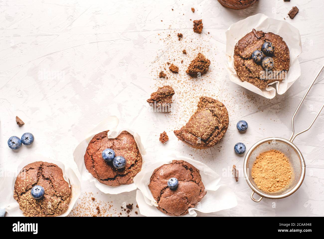 Hausgemachte, frische Schokoladenmuffins mit Beeren und Schokoladenstücken. Stockfoto