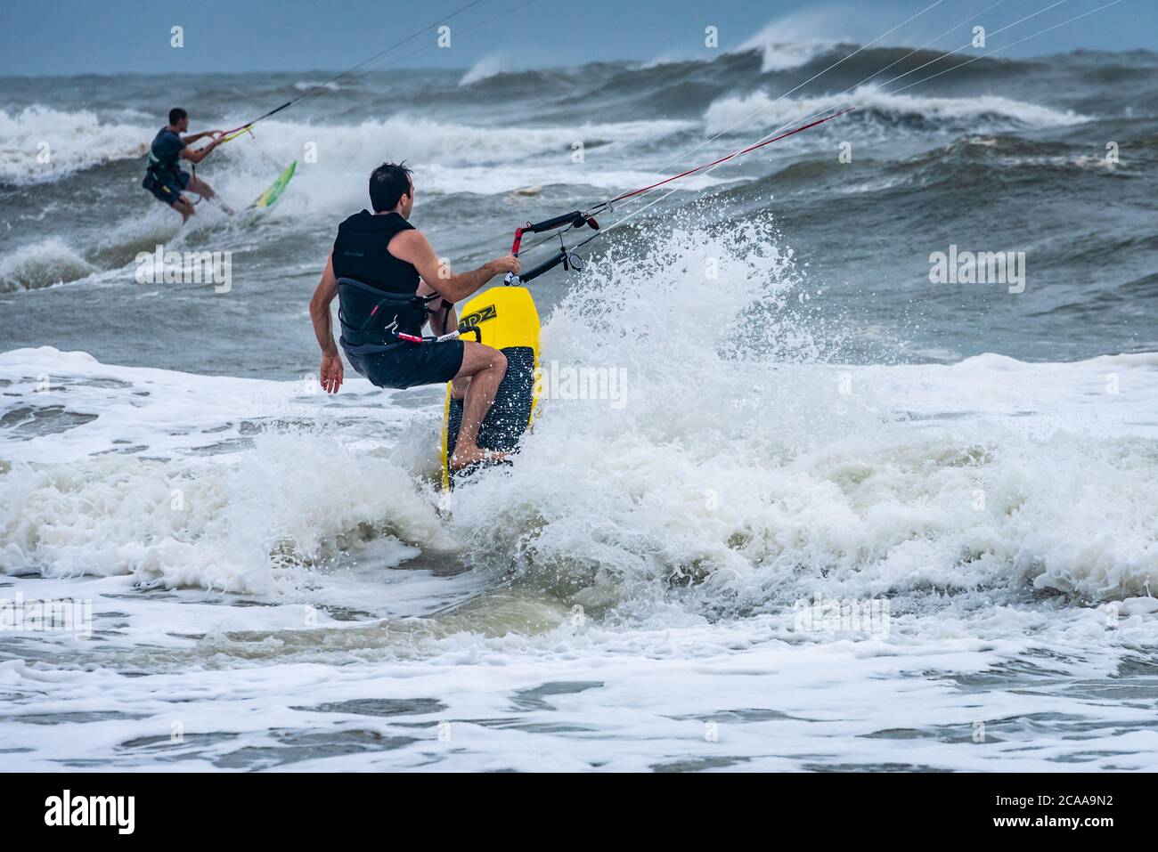 Kitesurfer, einschließlich Calvin Curry (Vordergrund), profitieren von den starken Winden und der großen Brandung, wenn der tropische Sturm Isaias Jacksonville Beach, FL, passiert. Stockfoto