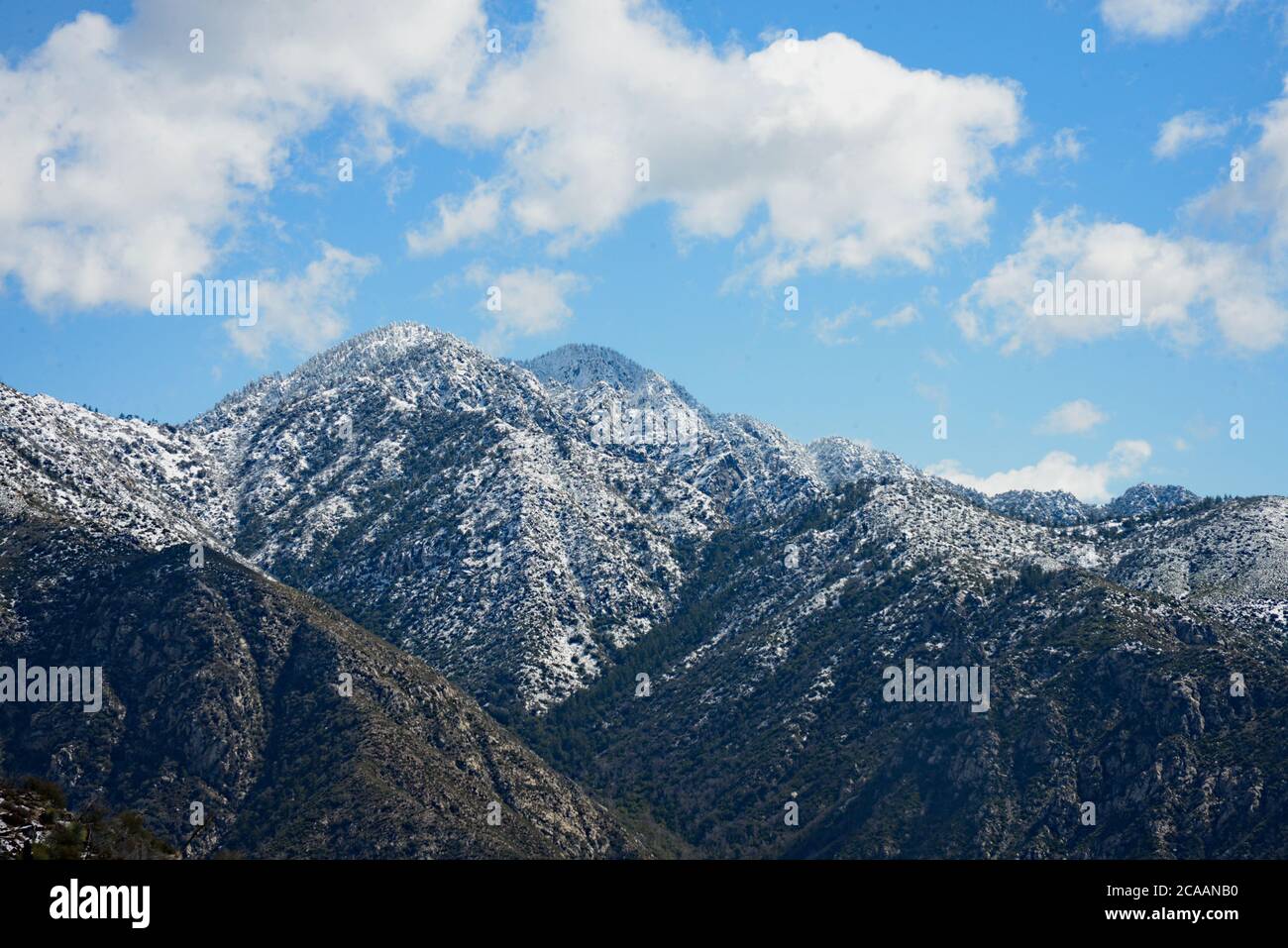 Beeindruckende Landschaft von schneebedeckten Bergen in der Ferne mit geschwollenen weißen Wolken schweben oben in schönen blauen Himmel kühn confident.beauty, Stockfoto