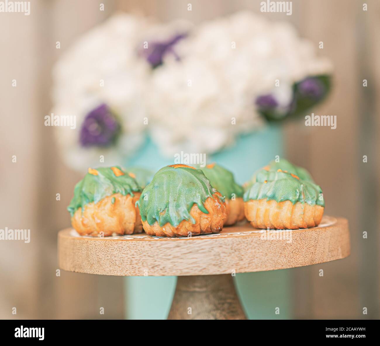 Pastellgrün Creme Puffs mit weißen Hortensien dekoriert. Stockfoto