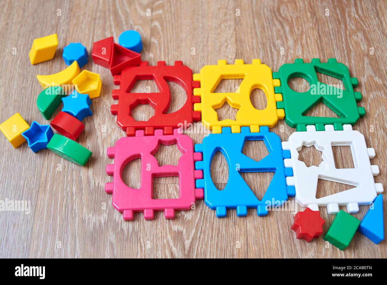 Pädagogische bunte Spielzeug Sortierer mit verschiedenen Formen auf einem hölzernen Hintergrund. Stockfoto