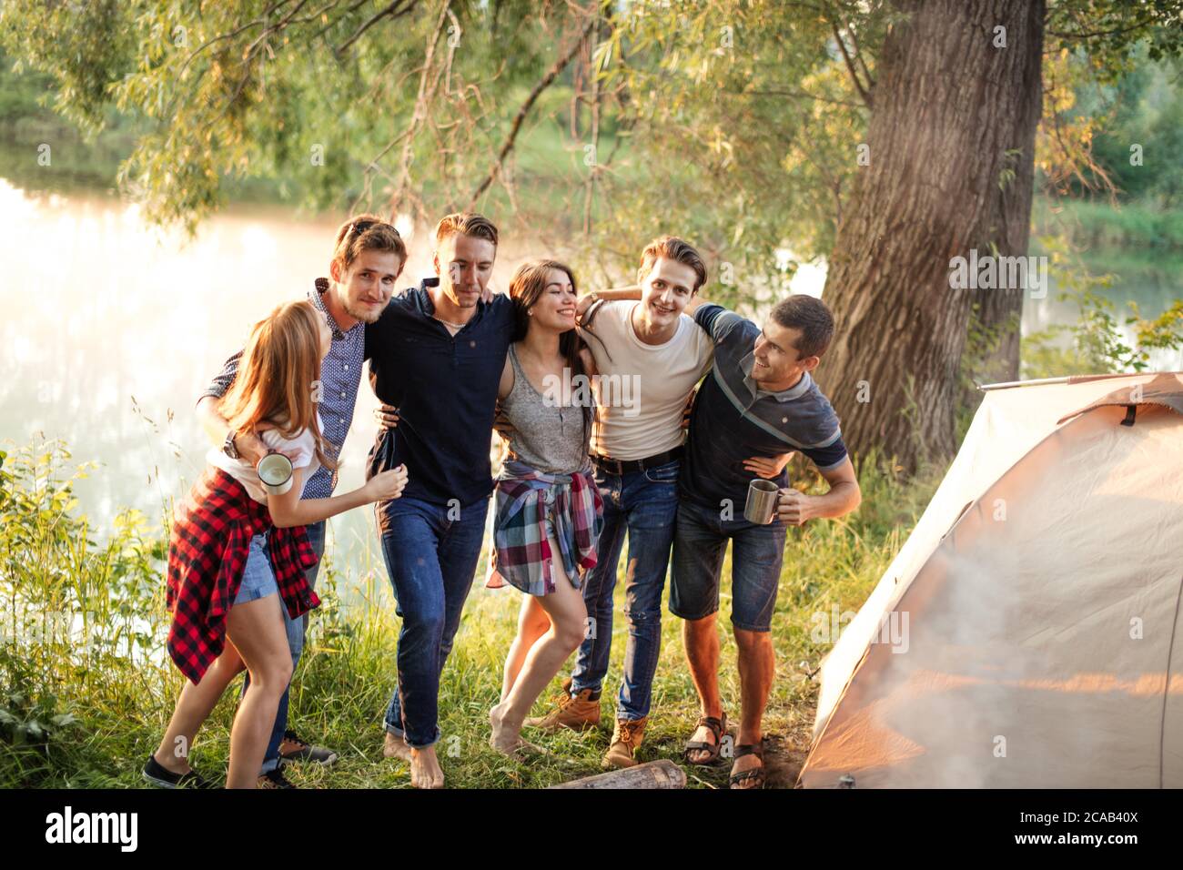 Junge Menschen umarmen sich am Campsight. Freundschaftskonzept Stockfoto
